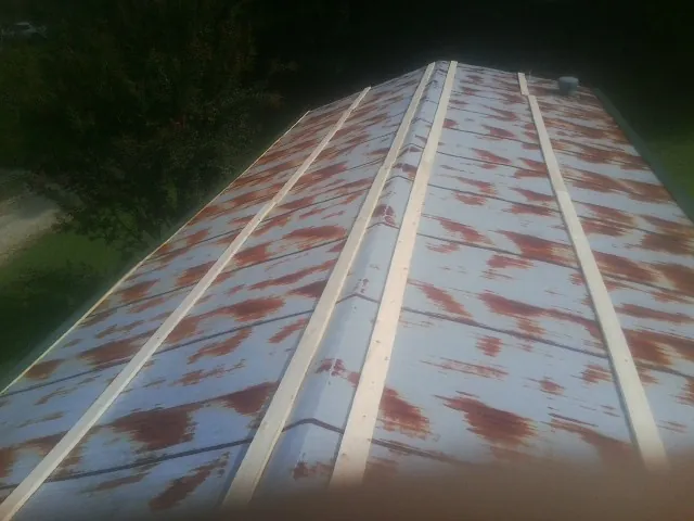 Rusted metal roof panels with new wood purlins before replacement — Storm Damage Roof Repair in Franklinton by Roofing Brothers